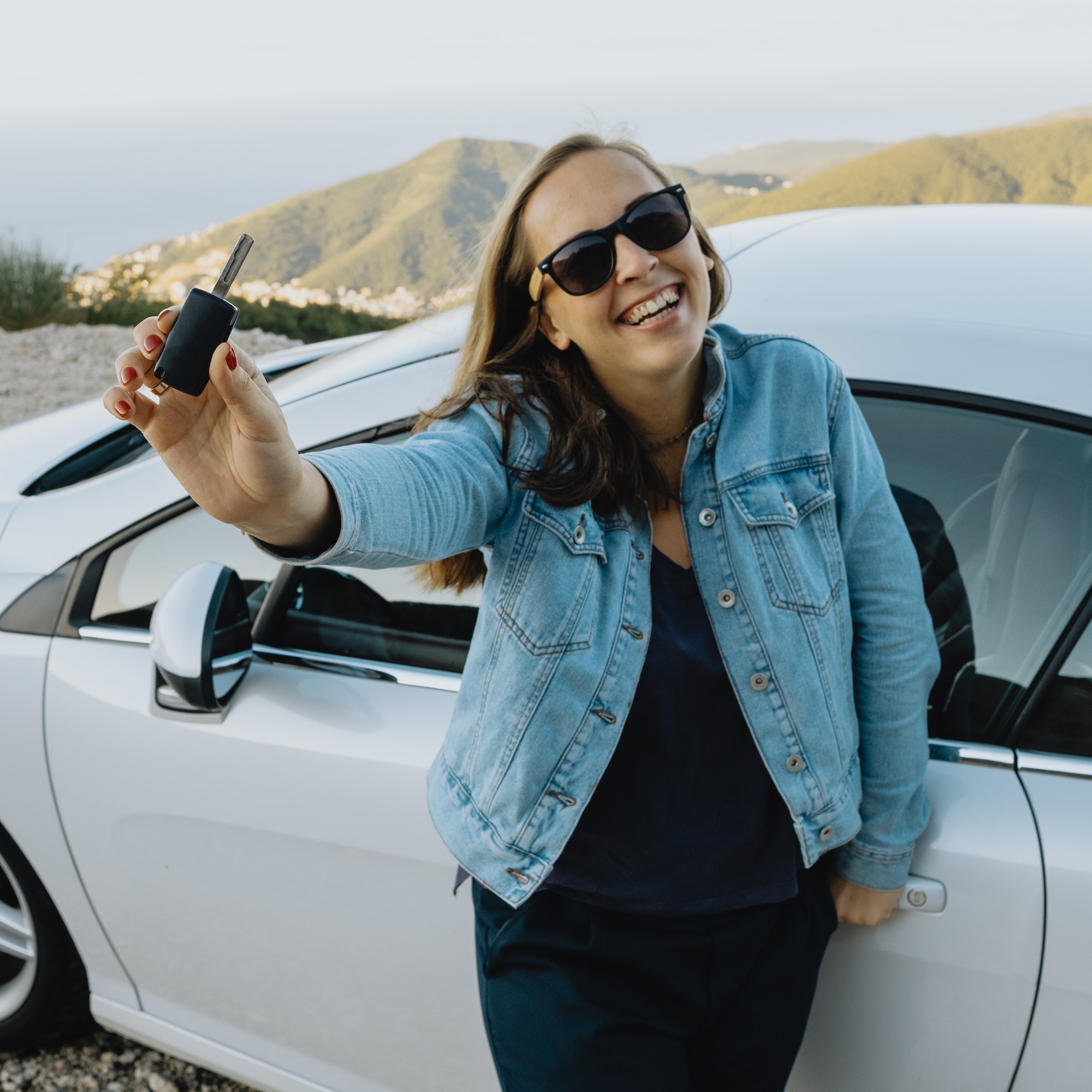 smiling woman showing new rental car keys
